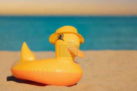 Foto de Divertido pato amarillo con sombrero de playa sobre fondo azul del mar y el cielo. Vacaciones de verano y concepto de viaje - Imagen libre de derechos