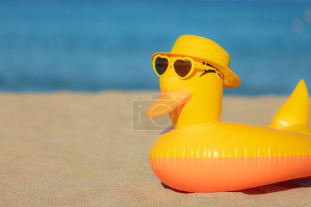 Photo for Funny yellow duck wearing beach hat and sunglasses against blue sea and sky background. Summer vacation and travel concept - Royalty Free Image