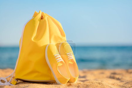 Photo for Beach bag and sneakers against blue sea and sky background. Summer vacation concept - Royalty Free Image