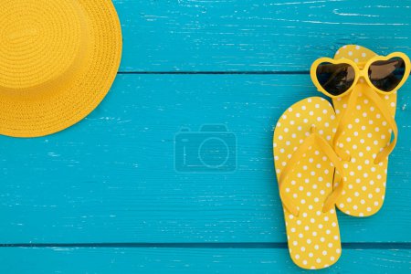 Foto de Chanclas de playa y gafas de sol sobre fondo de madera azul. Concepto de vacaciones de verano y viajes - Imagen libre de derechos