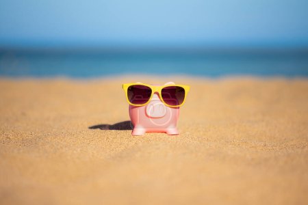 Photo for Piggybank on the beach against sea and sky background. Savings for summer travel and vacation concept - Royalty Free Image