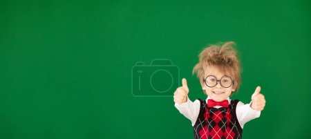 Photo for Funny child student in class. Happy kid against green chalkboard. Education concept. Back to school - Royalty Free Image