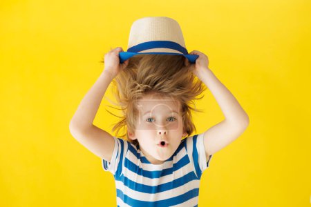 Photo for Surprised child holding face. Shocked kid against yellow background. Boy wearing striped shirt. Summer vacation and travel concept - Royalty Free Image