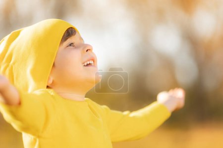 Photo for Portrait of happy child against yellow leaves background. Smiling kid having fun outdoor in autumn park. Freedom and imagination concept - Royalty Free Image