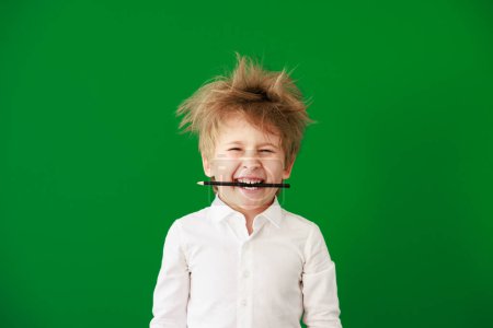 Téléchargez les photos : Joyeux enfant en classe. Enfant drôle sur fond de tableau vert. Retour à l'école et concept d'éducation - en image libre de droit
