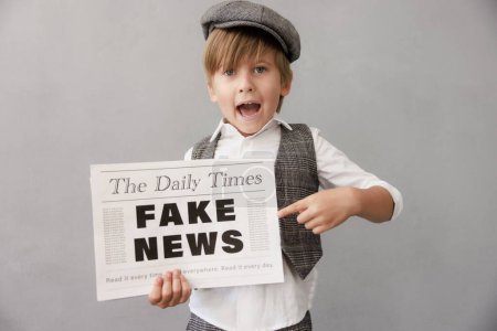 Photo for Newsboy shouting against grunge wall background. Boy selling fake news. Child wearing vintage costume. Kid holding newspaper. Social media and Internet nerwork concept - Royalty Free Image