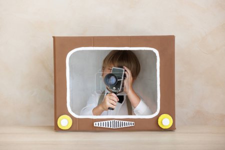 Photo for Director shouting against grunge wall background. Boy playing in home. Child wearing vintage costume. Kid holding camera. Social media and Internet nerwork concept - Royalty Free Image