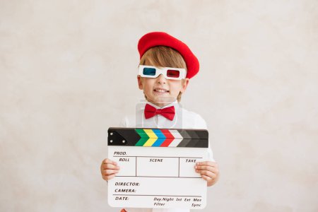 Photo for Director shouting against grunge wall background. Boy playing in home. Child wearing vintage costume. Kid holding clapper. Social media and Internet nerwork concept - Royalty Free Image