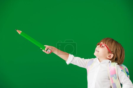 Photo for Funny child student in class. Happy kid against green chalkboard. Education and back to school concept - Royalty Free Image