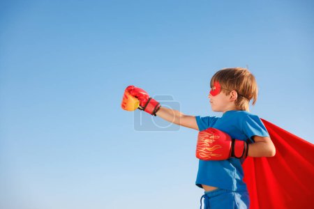 Foto de Niño superhéroe contra el cielo azul del verano. Super héroe chico divertirse outddor. concepto de estilo de vida saludable - Imagen libre de derechos