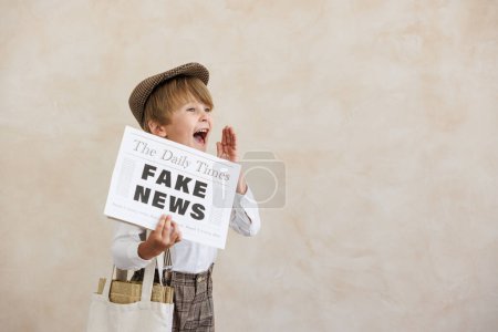 Newsboy schreit vor Grunge-Hintergrund. Junge verkauft Fake News. Kind im Vintage-Kostüm. Kind hält Zeitung. Soziales Medien- und Internet-Konzept