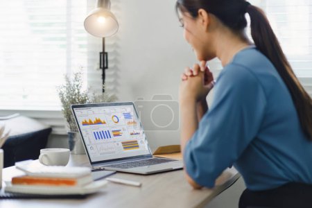 Foto de Analyst woman working with information database to analyze marketing and sales data. Business analytics dashboard with charts, metrics, and KPIs concept. - Imagen libre de derechos