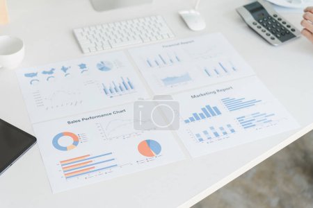 An array of business reports and marketing analysis charts are spread out on a desk, depicting various data visualization for strategic planning