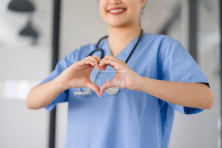Caring Nurse Making Heart Gesture in Clinic