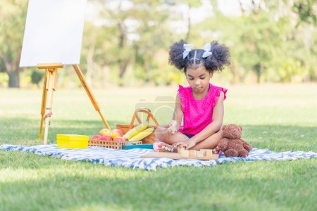 Foto de Niña jugando con juguete de madera al aire libre, linda niña jugar juguete en el jardín - Imagen libre de derechos