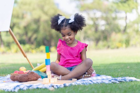 Photo for Cute little girl play toy at the garden, Child girl playing with little wooden toy outdoor - Royalty Free Image
