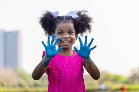 Photo for Cheerful little child girl showing painted hand, Cute little kid girl playing outdoors in the garden - Royalty Free Image