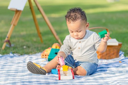 Photo for Cute little boy play toy at the garden, Child boy playing with little wooden toy cars outdoor - Royalty Free Image