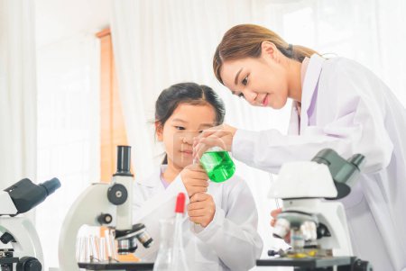 Foto de Clases de ciencias primarias, Profesora científica con niña en el laboratorio escolar, Laboratorio de ciencias - Imagen libre de derechos