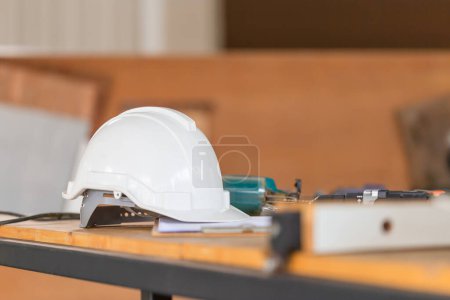 Photo for Construction concepts. White safety helmets on the engineering desks. Hard safety wear helmet hat on workbrench at construction site - Royalty Free Image