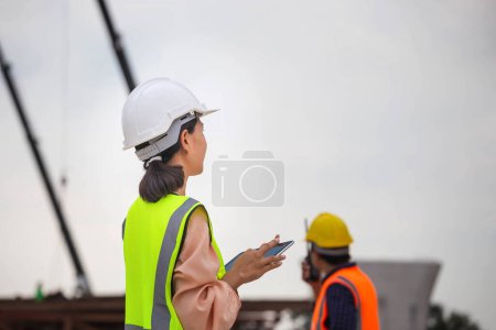 Photo for Female engineer and foreman worker checking project at building site, Engineer and builders in hardhats discussing on construction site, Teamwork concepts - Royalty Free Image