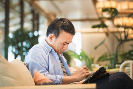 Foto de Hombre dibujando un gráfico en la tableta en una cafetería moderna, Hombre asiático usando una tableta, Tecnología en conceptos de uso - Imagen libre de derechos