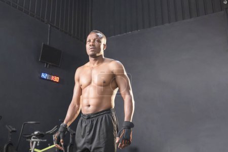 Foto de Joven hombre de pie fuerte en el gimnasio y la flexión de los músculos, Deporte y fitness conceptos - Imagen libre de derechos