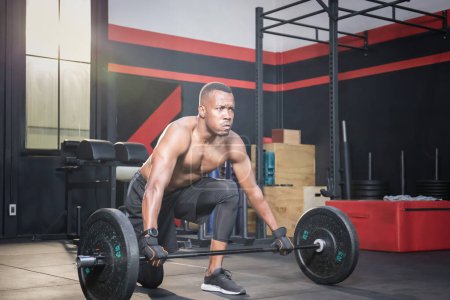Téléchargez les photos : Fitness homme soulevant des poids dans la salle de fitness, Musclé homme travaillant dans la salle de gym faire des exercices avec haltère poids - en image libre de droit