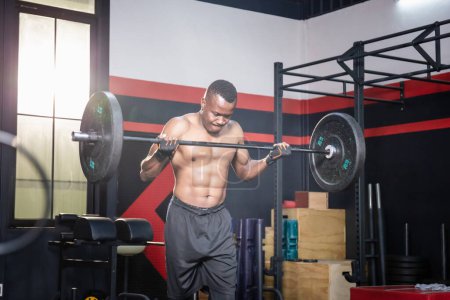 Photo for African American fitness man lifting weights in gym fitness, Muscular man working out in gym doing exercises with barbell weight - Royalty Free Image