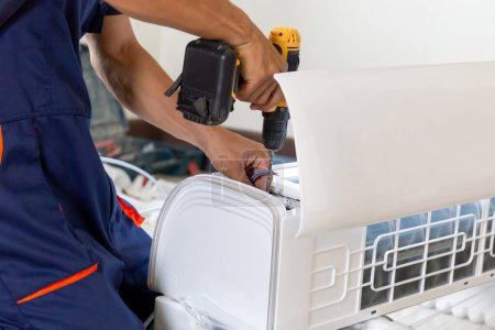 Photo for Technician man installing air conditioning in a client house, Repairman fixing air conditioner unit, Maintenance and repairing concepts - Royalty Free Image