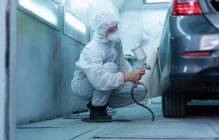 Photo for Mechanic painting car in chamber. Worker using spray gun and airbrush and painting a car, Garage painting car service repair and maintenance - Royalty Free Image