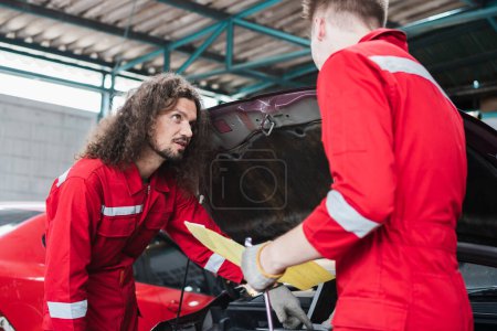 Photo for Young Caucasian car mechanic with a checklist, Mechanics in uniform are working in auto service, Technician checking modern car at garage, Car repair and maintenance concepts - Royalty Free Image