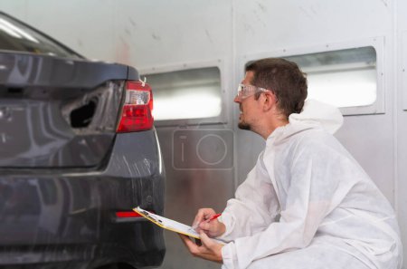 Photo for Auto mechanic repairman with a checklist, The mechanic man painting car in chamber, Garage painting car service repair and maintenance - Royalty Free Image