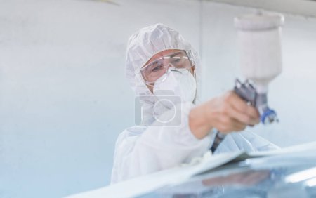 Photo for Mechanic painting car in chamber. Worker using spray gun and airbrush and painting a car, Garage painting car service repair and maintenance - Royalty Free Image