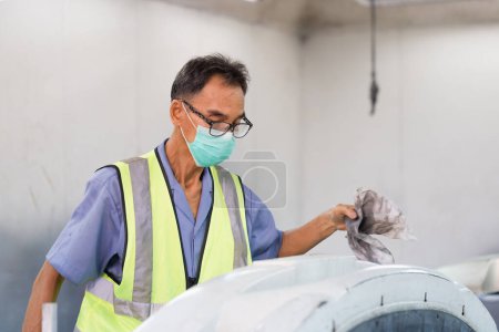 Téléchargez les photos : Mécanicien principal peignant la voiture dans la chambre, technicien vérifiant la qualité de la peinture, réparation et entretien de voiture de peinture de garage - en image libre de droit