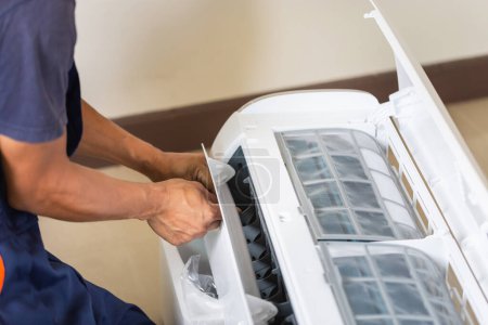 Téléchargez les photos : Technicien homme installant un climatiseur dans une maison cliente, Jeune réparateur réparateur unité de climatisation, Concepts d'entretien et de réparation - en image libre de droit