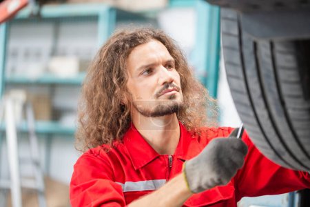 Téléchargez les photos : Jeune mécanicien automobile dans le garage de réparation, Technicien homme travaillant dans l'atelier de réparation automobile, concepts de réparation et d'entretien de voiture - en image libre de droit