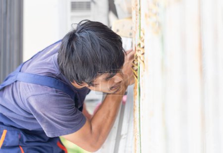 Téléchargez les photos : Jeune réparateur réparateur de climatiseur, Technicien installant un climatiseur dans une maison cliente, Concepts d'entretien et de réparation - en image libre de droit