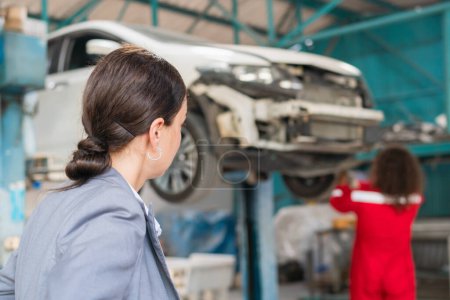 Photo for Female manager and auto mechanic in auto repair shop, Mechanic and young woman client talking together at the repair garage, Car repair and maintenance concepts - Royalty Free Image