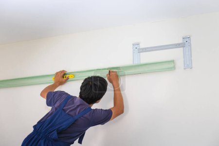 Photo for Young repairman fixing air conditioner unit, Asian technician man installing an air conditioning in a client house, Maintenance and repairing concepts - Royalty Free Image