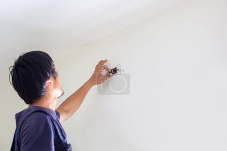 Photo for Technician man installing air conditioning in a client house, Electrician mounting the wires into wall, Repairman fixing air conditioner unit, Maintenance and repairing concepts - Royalty Free Image