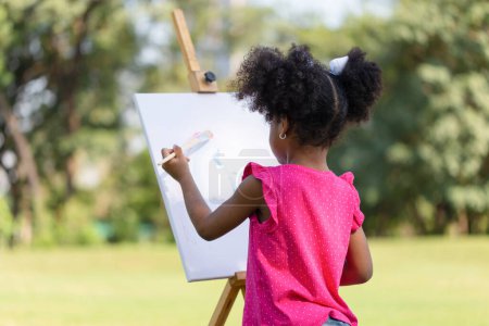 Photo for Kid girl painting on canvas in the garden, Happy child girl drawing a picture outdoors - Royalty Free Image
