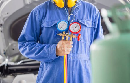 Photo for Car Air Conditioning Repair, Technician holding monitor tool to check and fixed car air conditioner system, Repairman check car air conditioning system refrigerant recharge - Royalty Free Image
