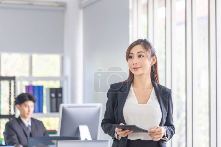 Foto de Mujer de negocios que trabaja en la oficina, Mujer joven sonriente con tableta, Dos jóvenes colegas de negocios en la oficina moderna - Imagen libre de derechos