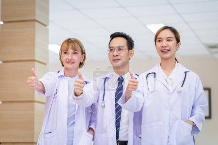 Photo for Team of medical doctors smiling while standing in the hospital, Doctors standing as a team showing thumbs up - Royalty Free Image
