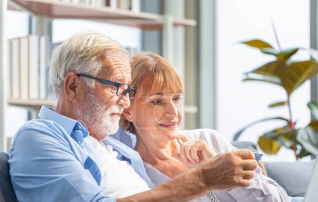 Téléchargez les photos : Gros plan de couple de personnes âgées femme et mari avec ordinateur portable achats en ligne à la maison, Beau vieil homme tenant la carte de crédit dans les mains - en image libre de droit