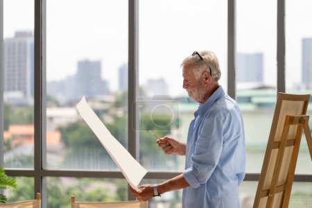 Téléchargez les photos : Senior homme tenant la peinture, Homme âgé artiste masculin dessin au studio d'art, Happy retirement concepts - en image libre de droit