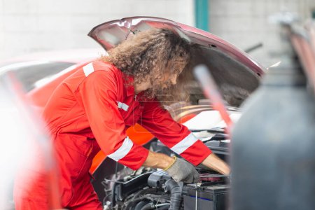 Foto de Hombre mecánico que trabaja en el almacén del garaje, mecánico joven que fija el coche en el taller de reparación de automóviles - Imagen libre de derechos