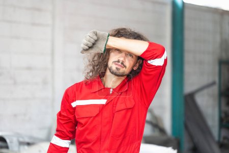 Photo for Tired the mechanic man in repair garage, Technician man put his hand to his head in auto repair shop, Car repair, and maintenance concepts - Royalty Free Image
