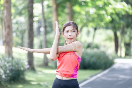 Photo for Sport woman warming up outdoors, Fitness woman doing stretch exercise stretching her arm - Royalty Free Image